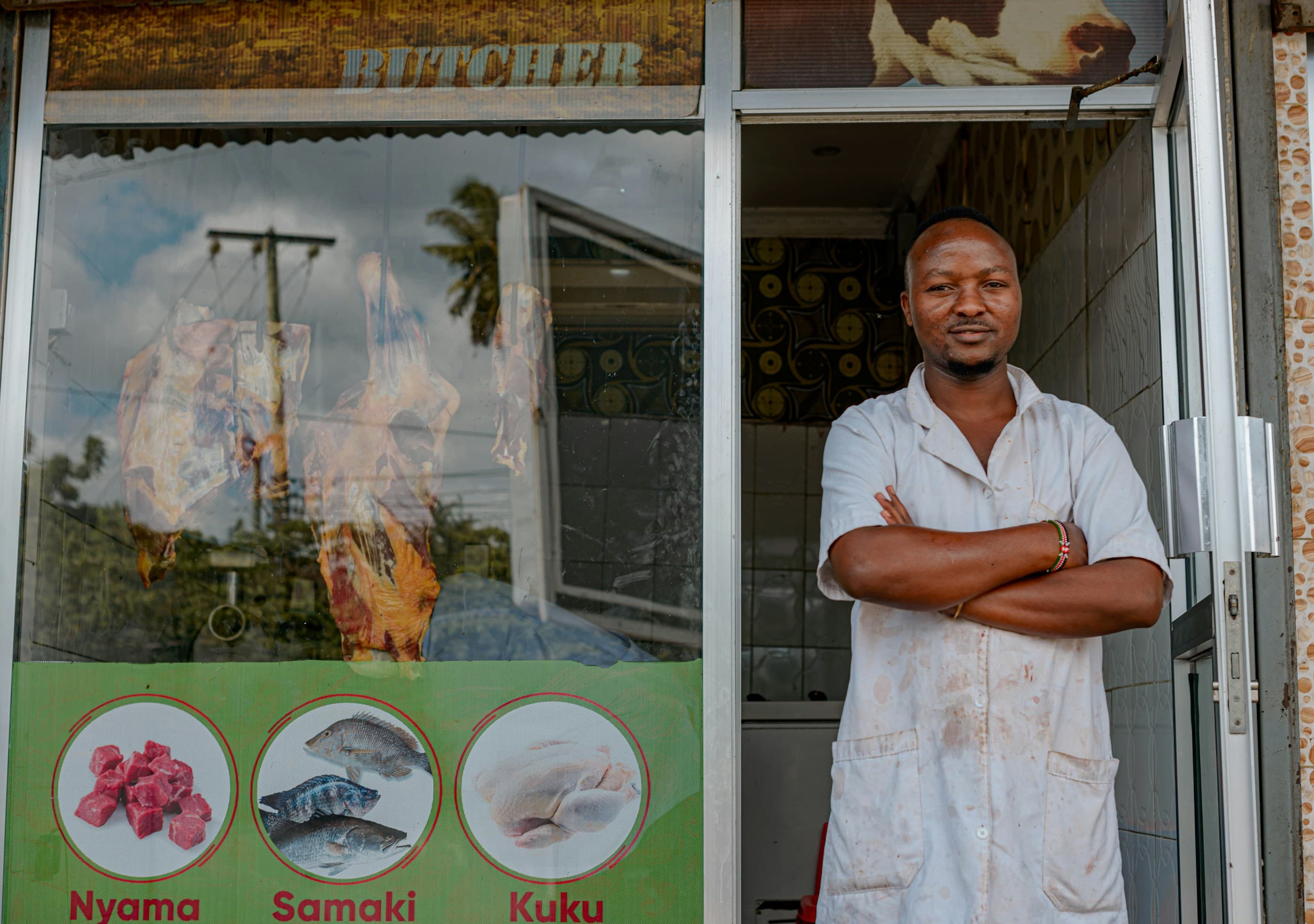 A shop owner standing in his doorway with arms crossed