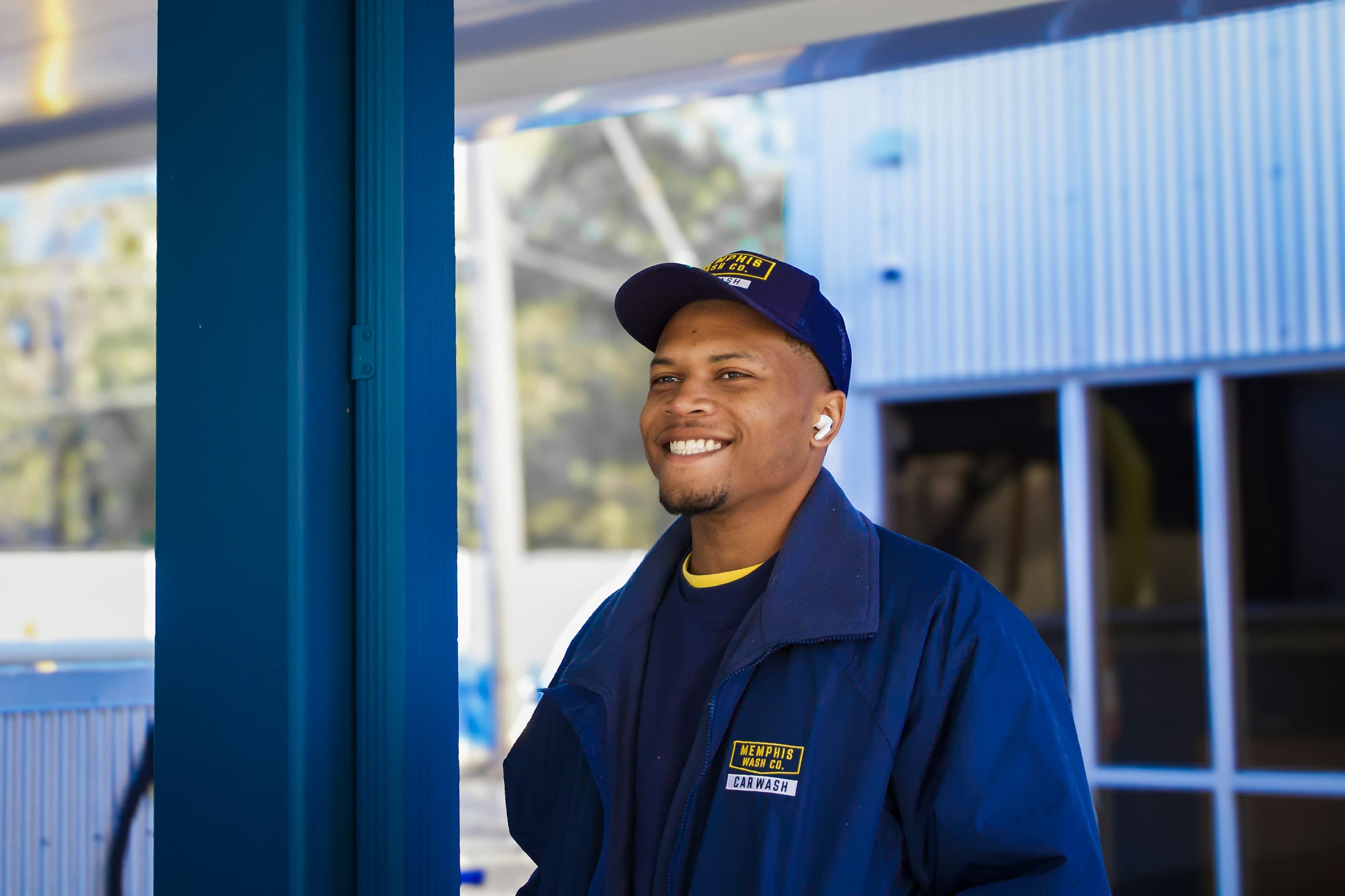 A service technician in a blue uniform outside a building